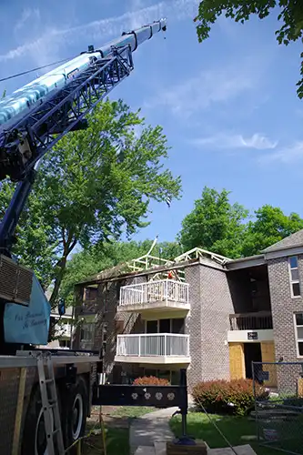 Crane installing roof trusses at apartment complex