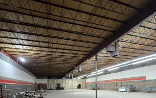 Wide view of interior demolition phase with open ceiling and partially removed walls during retail space renovation by Omega Contracting & Consulting