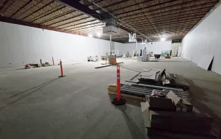 Retail interior space with completed drywall, electrical, and HVAC rough-in nearing final stages of construction