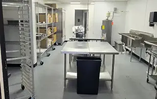 Commercial kitchen installation – Stainless steel prep tables and shelving in progress at Graze Craze Ellicott City’s new kitchen.