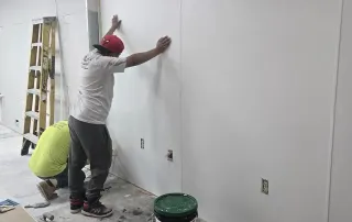 Team installing wall panels – Omega Contracting crew securing new wall finishes inside Graze Craze Ellicott City.