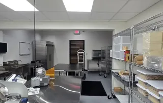 Finished kitchen space – Completed commercial kitchen with stainless steel equipment and shelving at Graze Craze Ellicott City.