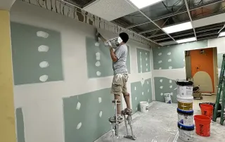 Drywall finishing work – Omega Contracting crew applying joint compound to new walls during Graze Craze Ellicott City renovation.